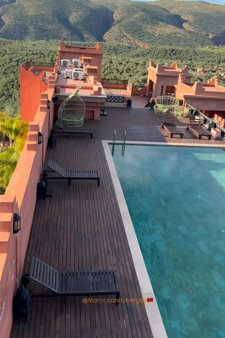 Piscine sur toit-terrasse en bois, entourée de collines verdoyantes