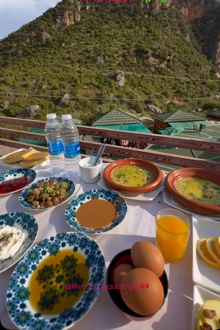 Petit-déjeuner marocain dressé sur une terrasse face à la montagne