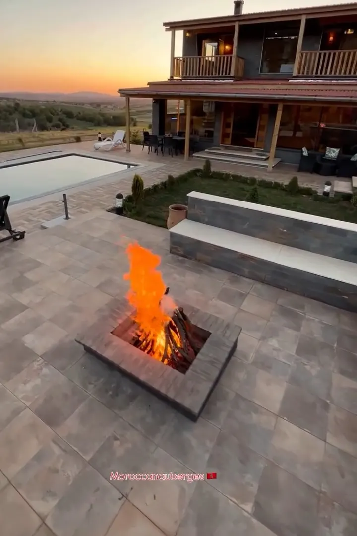 Chalet en bois avec piscine et feu de bois au coucher du soleil