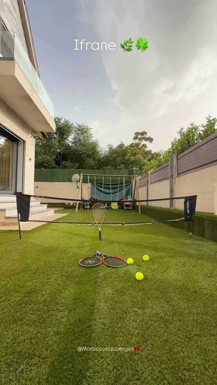 Jardin avec terrain de tennis et espace de jeux pour enfants
