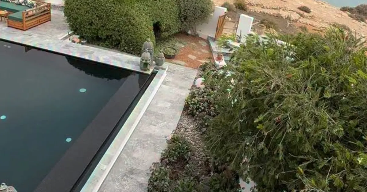 Piscine à débordement et terrasse en pierre dominant la côte rocheuse, à Imsouane